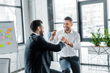 cheerful businessmen toasting with glasses of whiskey