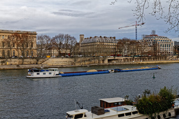 Naklejka premium 18 DEC 2018 - Paris, France - Barge coming down the Seine river