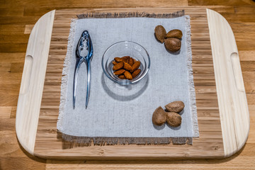 Some kind of the nuts, walnuts, almond, hazelnut with the equipment to open the nuts and on the wooden desk