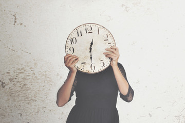 surreal photo of a woman hiding behind a big clock