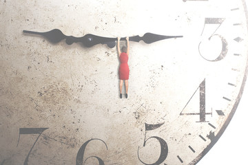   business woman trying to stop the time hanging on the hand of a clock