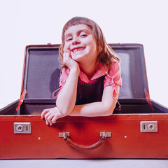 I am happy to travel, I am ready for the trip! Happy cute little child girl sitting on vintage suitcase. © zwiebackesser