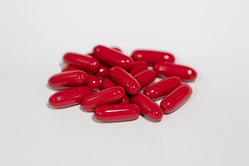 Closeup red supplement softgel capsules 1200 mg isolated with white background 