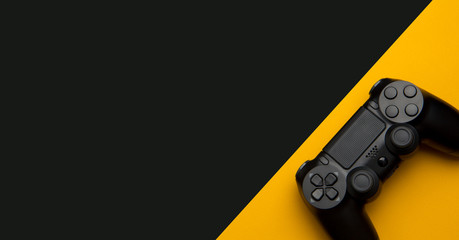 black wireless gamepad on a black and yellow background © solidmaks