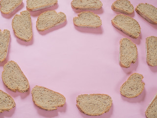 Bread with seeds pattern on pink background with copy space