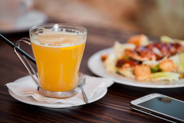 cup of sea ​​buckthorn tea and salad in background 