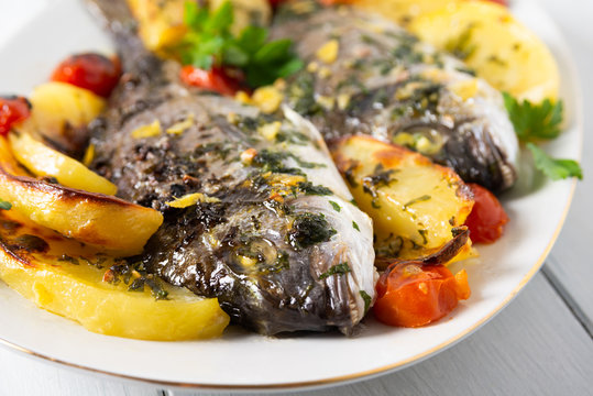 Portata di orate al forno con patate e pomodorini 