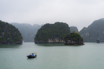 Fototapeta na wymiar Halong Bay in mystical clouds. Mystical atmoshpere in the world famous halong bay.