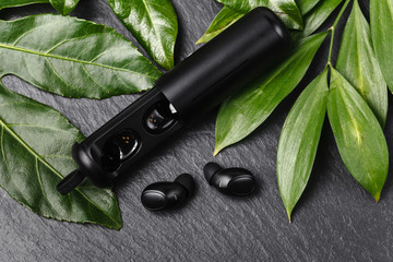 Wireless earphones close up view on black stone