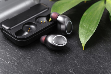 Wireless earphones close up view on black stone