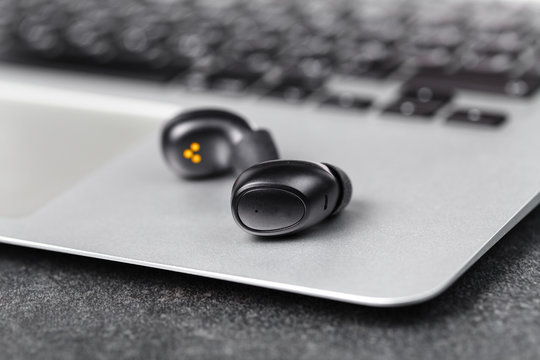 Wireless earphones close up view on black stone