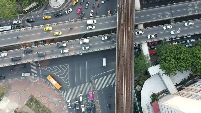 Footage of drone above the BTS rails in Bangkok at susnet with all cars driving on the road