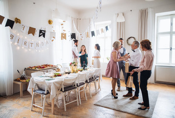 Multigeneration family with presents on a indoor birthday party.