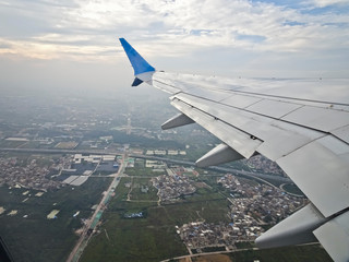 View from the window of an airplane taking off with a wing - a flight over the city.