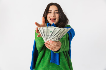 Portrait of optimistic woman 30s in casual clothes holding fan of dollar money, while standing isolated over white background