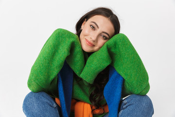 Image of lovely woman 30s in colorful clothes propping her head while sitting on the floor,...