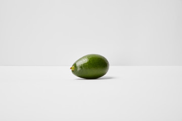 selective focus of whole avocado on grey background