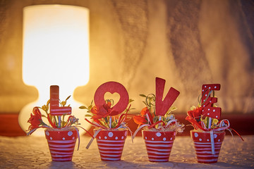 Love letters in flower pots in the light of a lamp.