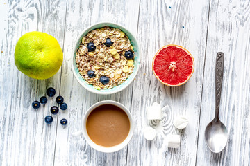 Breakfast concept with flowers on wooden background top view