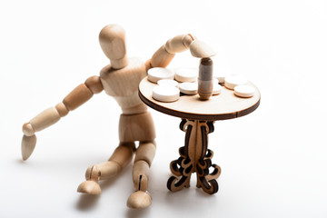 Medication regimen. Human wooden dummy near table with medicines. Tips tackling complex medication regimen. Take medicines after food. Health care and medical treatment. Pills on tiny wooden table
