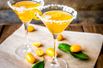 cocktail with kumquat on wooden background