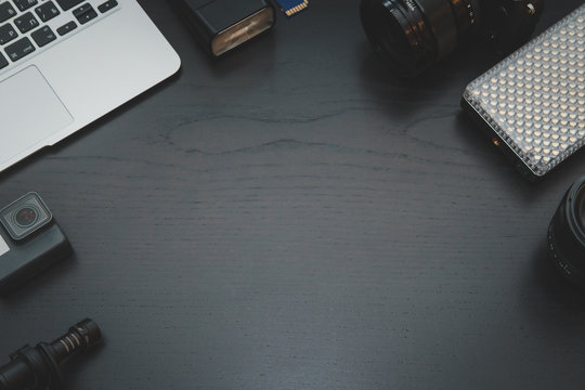 GoPro, MacBook Air, camera lens on lights on dark wooden desk