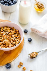 Fitness breakfast with granola, milk and honey on white background