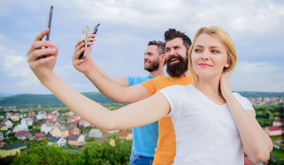Selfie with no filter. Best friends taking selfie with camera phone. Pretty woman and men holding smartphones in hands. People shooting selfie on natural landscape. Sharing selfie on social network