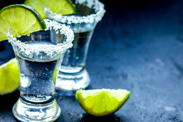 Alcohol shots with lime and salt on black background