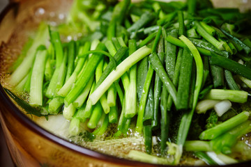 Cooking garlic chives in pot 
