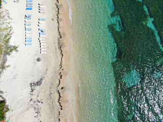 Aerial view of the Caribbean Sea with beach chairs at Reggae Beach near Christopher Harbor, Saint Kitts