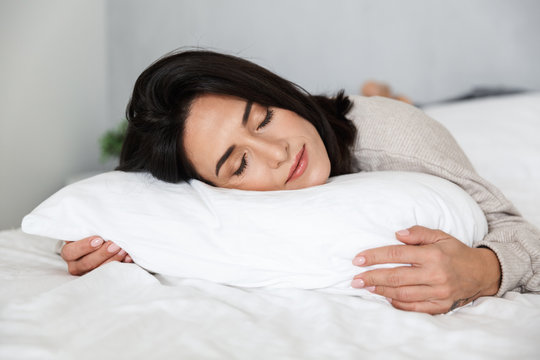 Photo Of Adult Woman 30s Sleeping, While Lying In Bed With White Linen At Home