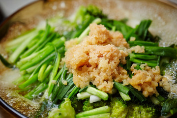 Cooking garlic chives and grated ginger
