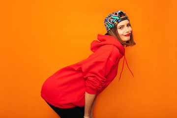 cool hipster girl with colored hat on orange