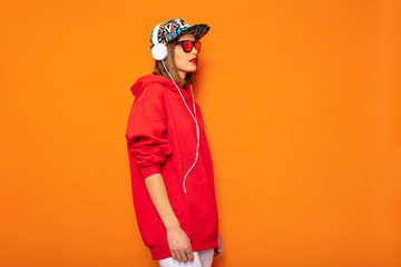 young girl in red hoodie on orange background