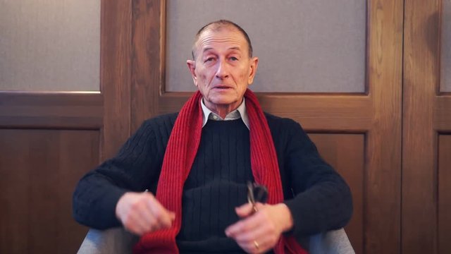 Businessman presentating business company. Senior man speaks to camera.