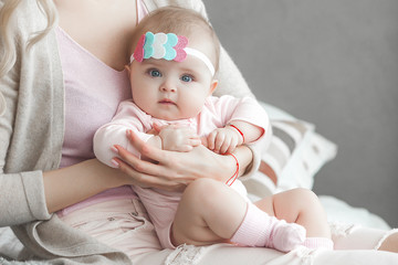 Cute litttle baby at home in the bedroom. An infant indoors. 6th month child portrait. Adorable...