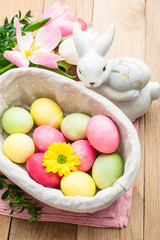 Easter, painted eggs in a basket on a wooden background, tulips, spring Christian holiday