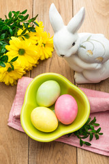 Easter, 3 eggs in a green plate on a wooden background, a spring Christian holiday