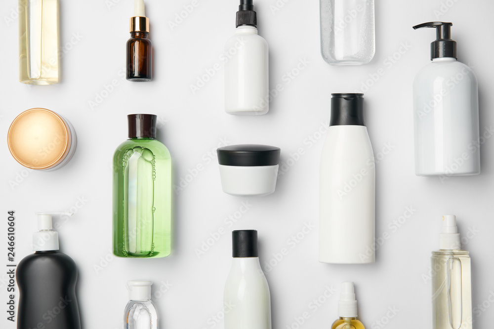 Wall mural top view of different cosmetic bottles and container on white background