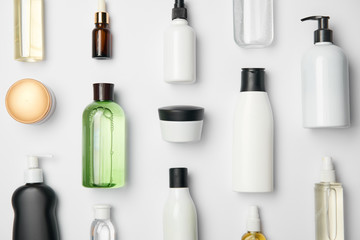 Top view of different cosmetic bottles and container on white background - obrazy, fototapety, plakaty