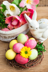Easter, colored painted eggs, a nest on a wooden background, spring Christian holiday