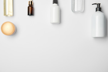 Top view of different cosmetic bottles on white background with copy space