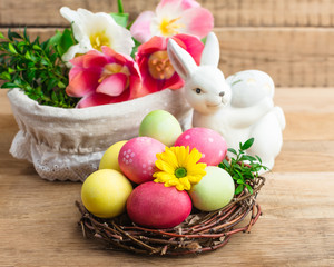 Easter, colored painted eggs, a nest on a wooden background, spring Christian holiday