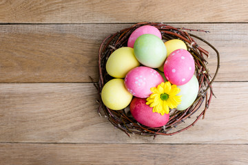 Easter, colored painted eggs, a nest on a wooden background, spring Christian holiday
