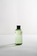 transparent cosmetic bottle with shampoo on white background with copy space