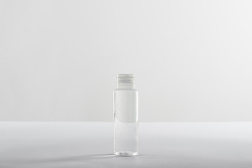 Cosmetic bottle with transparent liquid on white background with copy space