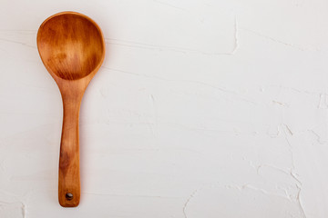 Wooden spoon on white background with texture. Space to insert your text here. Letter for restaurants. (Food concept of spoon, pot).