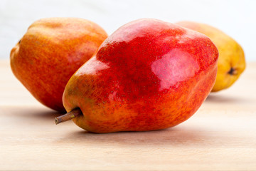 Delicious red pears. On light wood background.