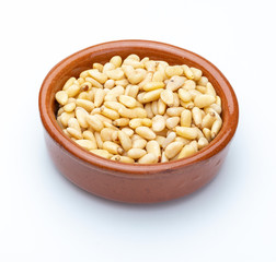 Pine nuts in clay bowl (Collection of various nuts). Isolated on white background.